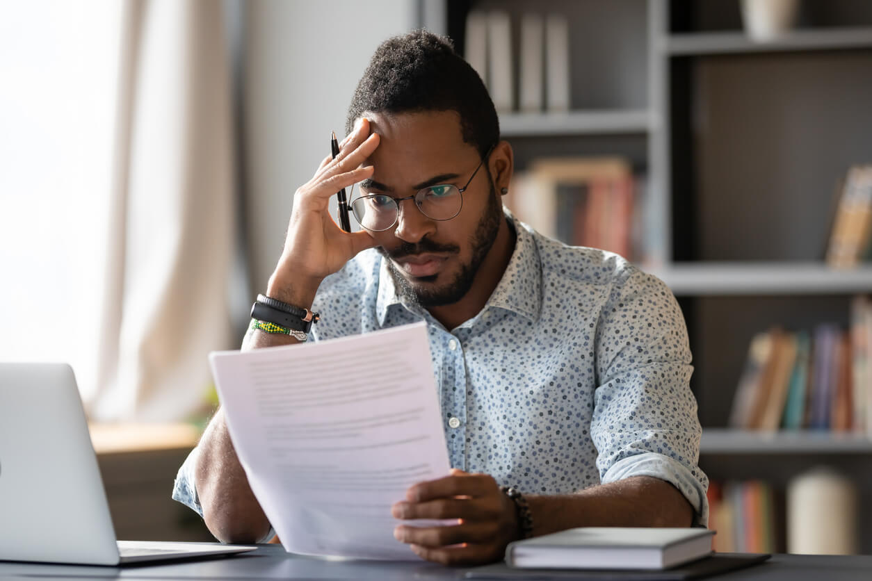 worried man looking at invoice